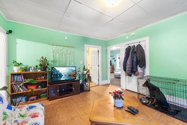living area featuring a paneled ceiling