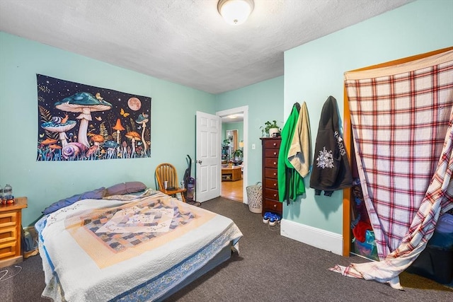 carpeted bedroom with baseboards and a textured ceiling