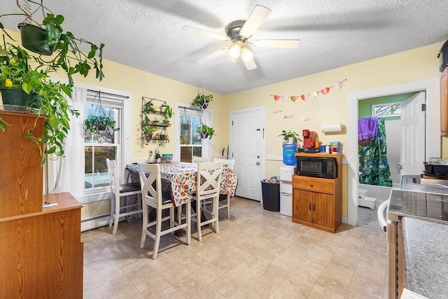 dining space featuring a ceiling fan and a textured ceiling