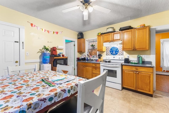 kitchen featuring brown cabinets, dark countertops, ceiling fan, under cabinet range hood, and white electric range
