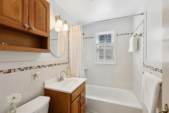 full bathroom featuring toilet, shower / bath combo with shower curtain, tile walls, and vanity