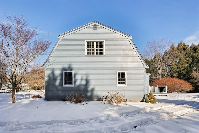 view of snow covered exterior with a gambrel roof