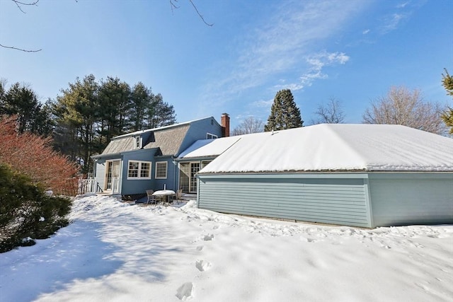 view of front of home with a chimney and a gambrel roof