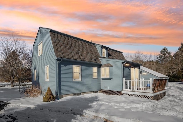 exterior space with roof with shingles and a gambrel roof