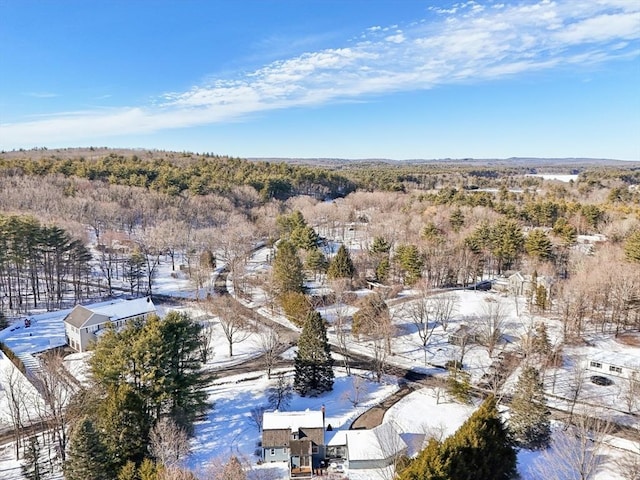 snowy aerial view with a wooded view