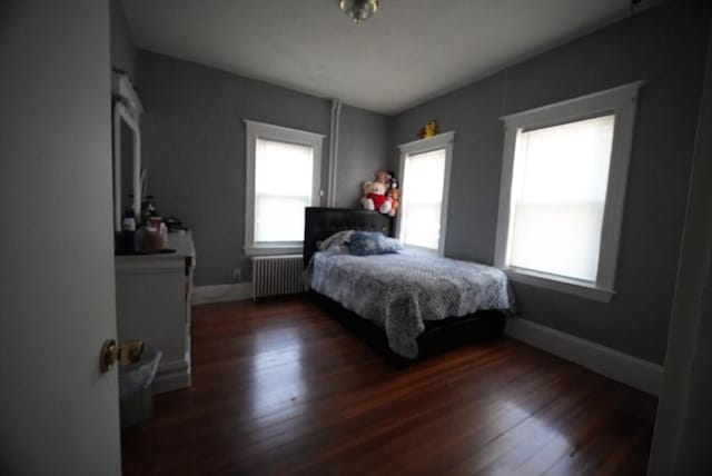 bedroom featuring radiator, dark wood-style flooring, and baseboards