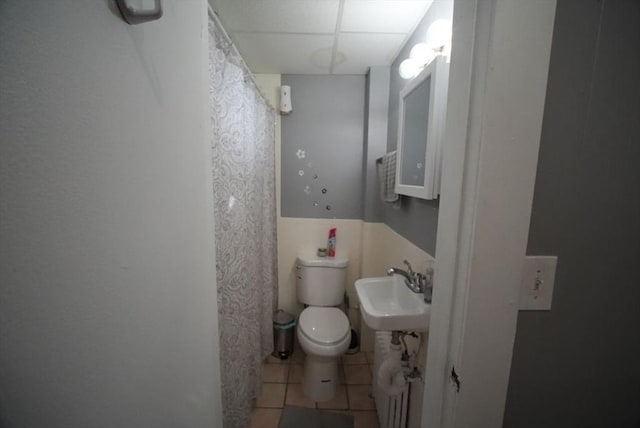 full bathroom featuring tile patterned floors, toilet, a sink, and curtained shower