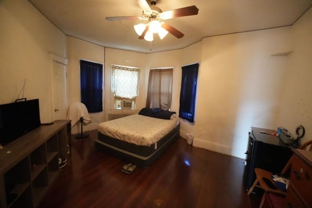 bedroom with dark wood-type flooring, radiator heating unit, ceiling fan, and cooling unit