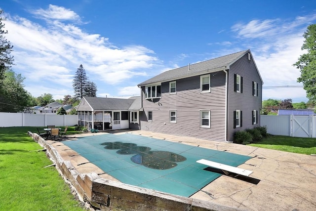 view of swimming pool featuring a diving board, a patio area, and a gate