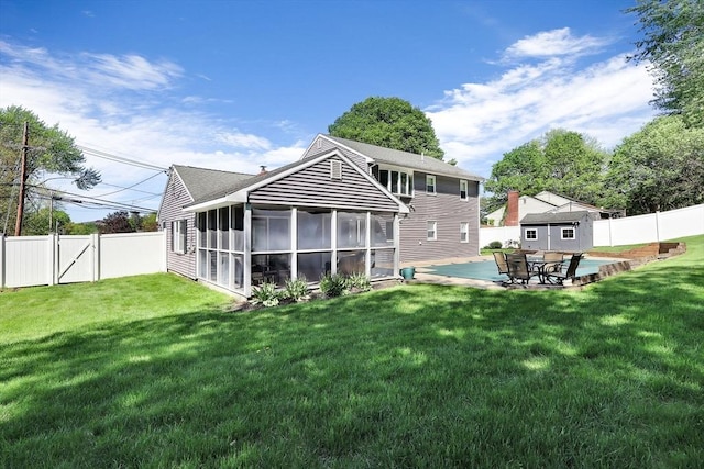 rear view of house featuring a sunroom and a patio