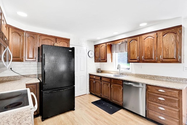 kitchen featuring appliances with stainless steel finishes, a sink, tasteful backsplash, light countertops, and recessed lighting