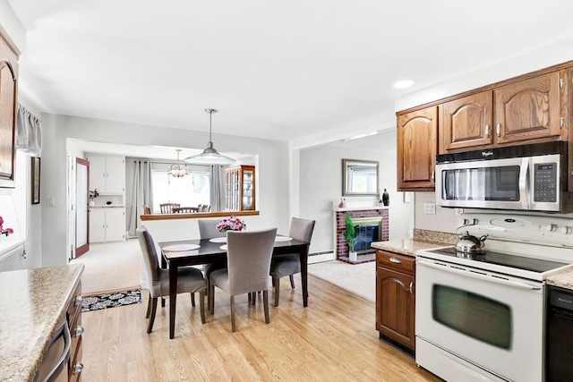 kitchen featuring stainless steel microwave, electric stove, a baseboard heating unit, and light countertops