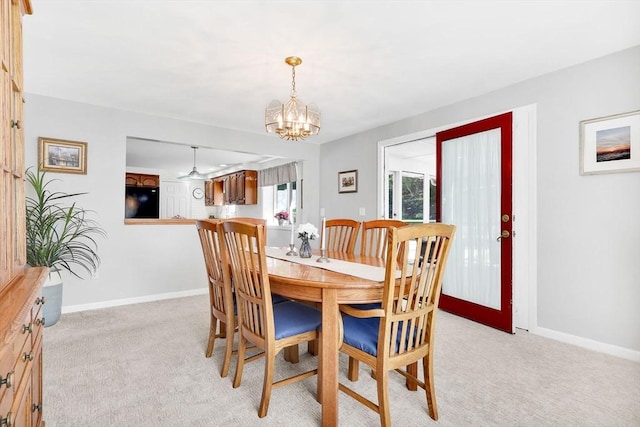 dining area with a chandelier, light carpet, and baseboards