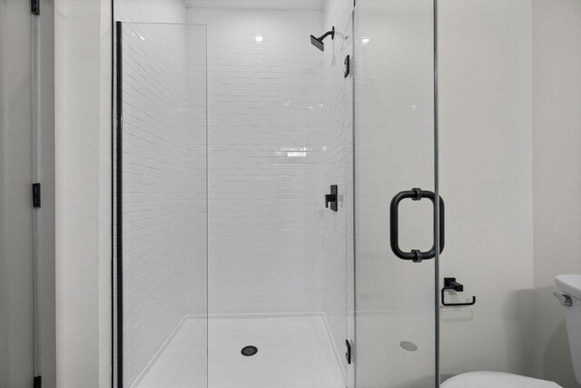 bathroom with a shower stall and toilet