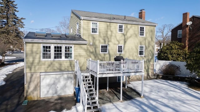 back of property featuring a garage and a deck