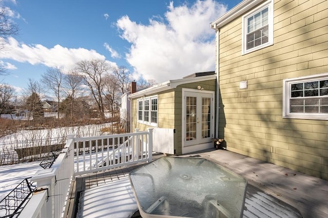 snow covered deck featuring french doors