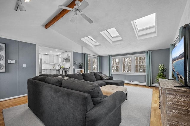 living room featuring ceiling fan, lofted ceiling with beams, and light hardwood / wood-style flooring