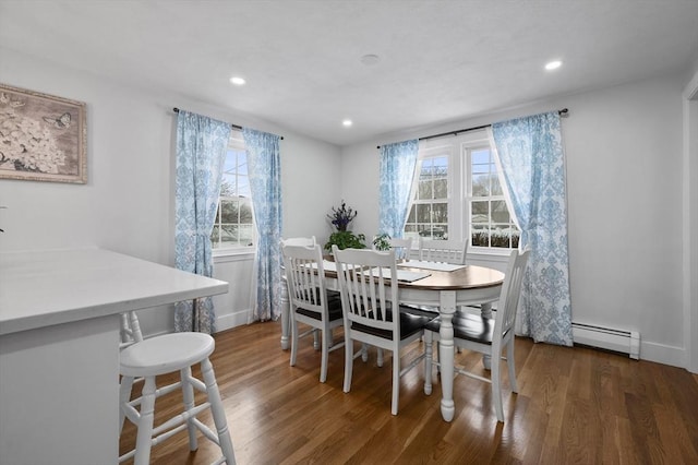 dining space with dark hardwood / wood-style flooring and a baseboard heating unit