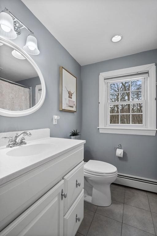 bathroom with tile patterned floors, vanity, toilet, and a baseboard heating unit