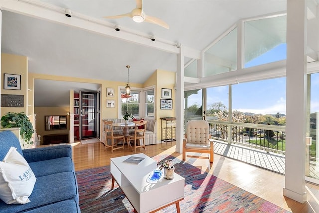 living room with wood finished floors, high vaulted ceiling, ceiling fan, and beamed ceiling
