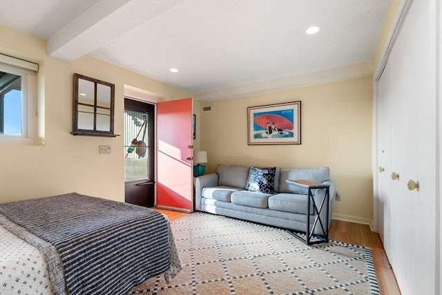 bedroom with light wood-style floors, recessed lighting, baseboards, and a closet
