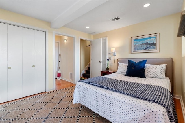 bedroom with beam ceiling, recessed lighting, a closet, baseboards, and wood finished floors