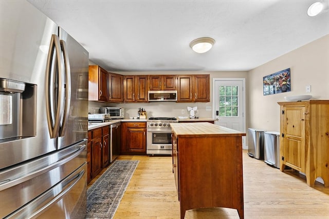 31 Wight St, Waltham, MA 02452 - kitchen with light wood-style flooring, stainless steel appliances, a toaster, a kitchen island, and butcher block counters