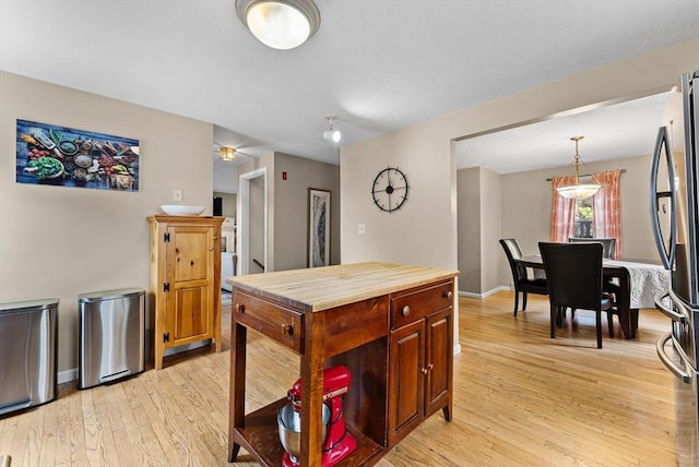 31 Wight St, Waltham, MA 02452 - kitchen with freestanding refrigerator, pendant lighting, butcher block countertops, baseboards, and light wood-type flooring