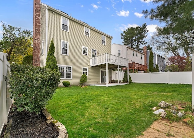 31 Wight St, Waltham, MA 02452 - back of house with a lawn, a fenced backyard, a chimney, and a deck