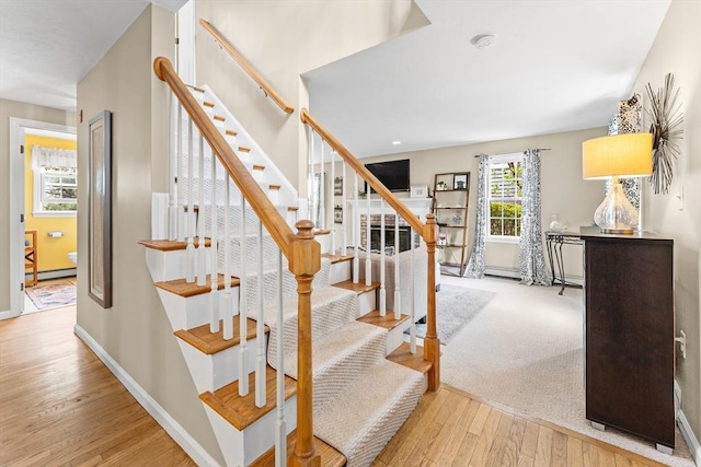 31 Wight St, Waltham, MA 02452 - stairs featuring baseboards, wood finished floors, and a baseboard radiator