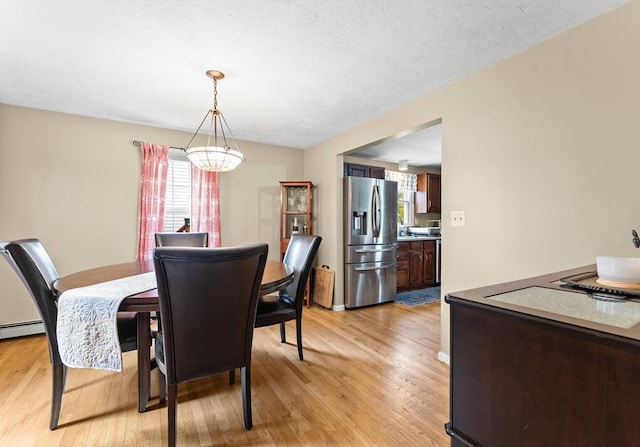 31 Wight St, Waltham, MA 02452 - dining area with light wood finished floors, a chandelier, and a wealth of natural light