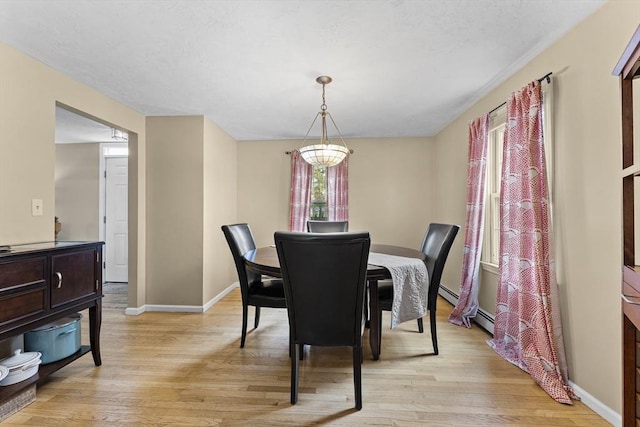 31 Wight St, Waltham, MA 02452 - dining room with light wood-type flooring, baseboards, and a baseboard heating unit