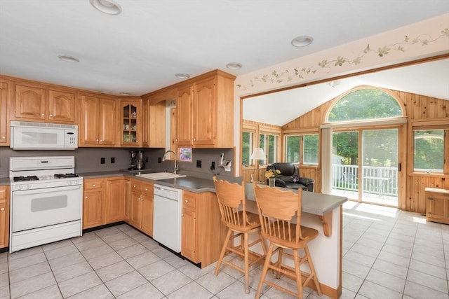 221 Andrew Ln, Hanson, MA 02341 - kitchen featuring white appliances, vaulted ceiling, a peninsula, light tile patterned flooring, and a kitchen breakfast bar
