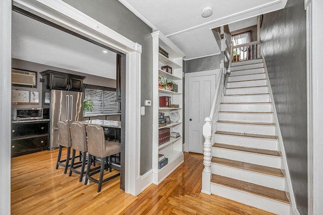 stairs featuring built in features and a wall mounted air conditioner