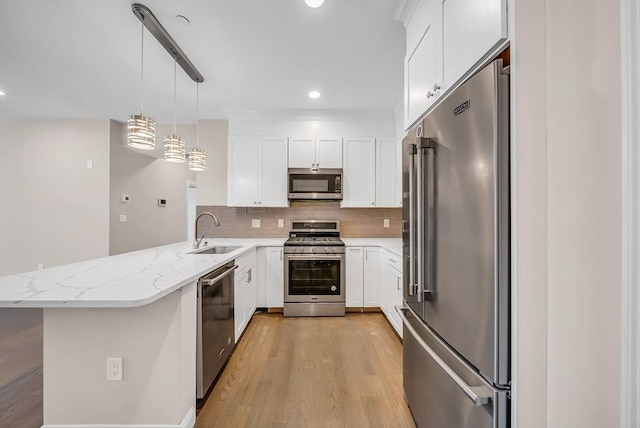 966 Hyde Park Ave Unit 301, Boston, MA 02136 - kitchen featuring appliances with stainless steel finishes, a sink, a peninsula, decorative backsplash, and light wood-style floors