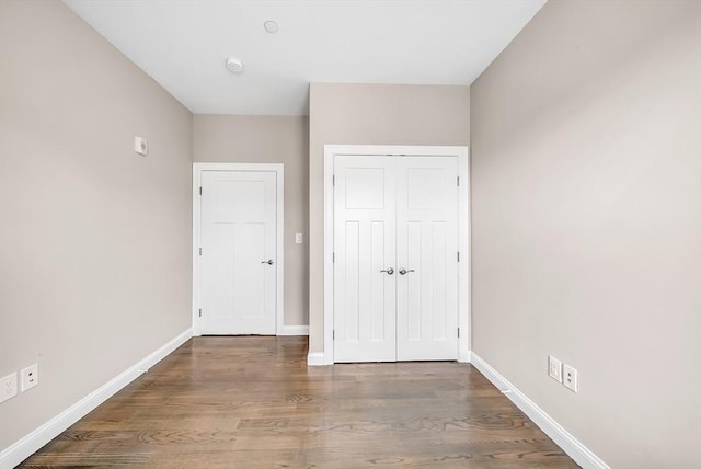 966 Hyde Park Ave Unit 301, Boston, MA 02136 - unfurnished bedroom featuring baseboards, wood finished floors, and a closet
