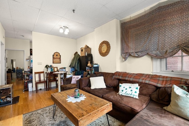 living room with a paneled ceiling and wood finished floors