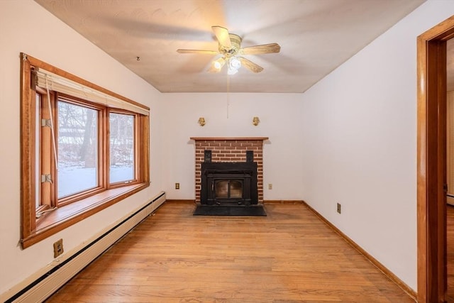 unfurnished living room with ceiling fan, a baseboard heating unit, and light hardwood / wood-style floors