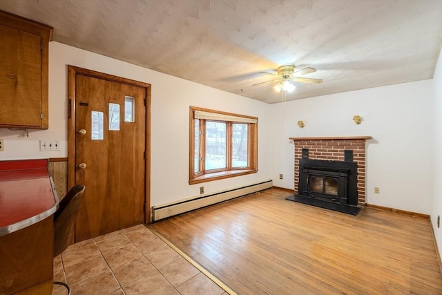 unfurnished living room featuring a baseboard radiator, ceiling fan, and light wood-type flooring