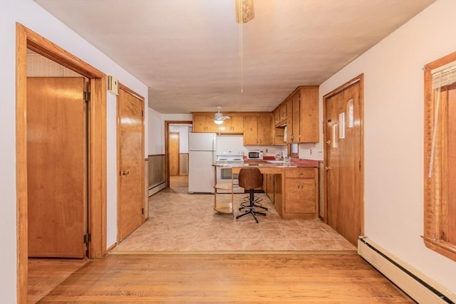 kitchen with a kitchen bar, white appliances, light wood-type flooring, and baseboard heating