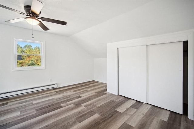 additional living space featuring ceiling fan, a baseboard radiator, wood-type flooring, and vaulted ceiling