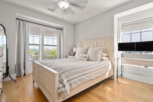bedroom featuring visible vents, a ceiling fan, multiple windows, and light wood-type flooring
