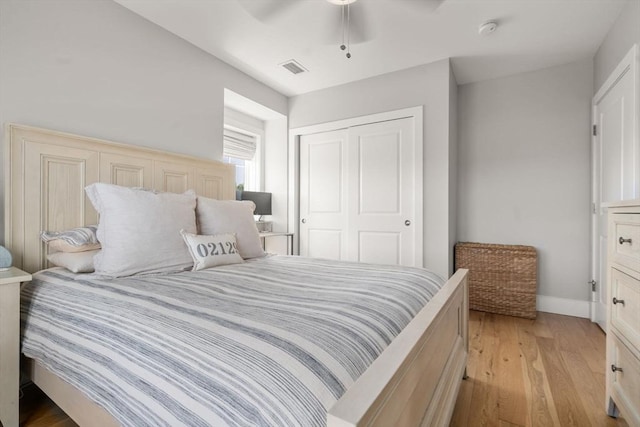 bedroom with a closet, visible vents, baseboards, ceiling fan, and light wood-type flooring