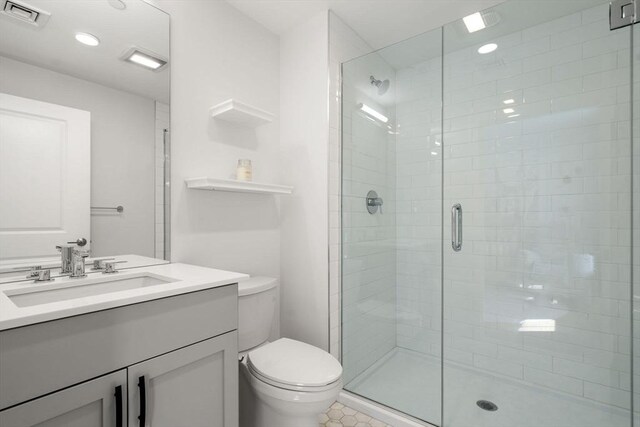 full bathroom featuring visible vents, tile patterned flooring, vanity, toilet, and a shower stall