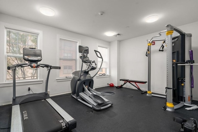 gym with baseboards and a healthy amount of sunlight