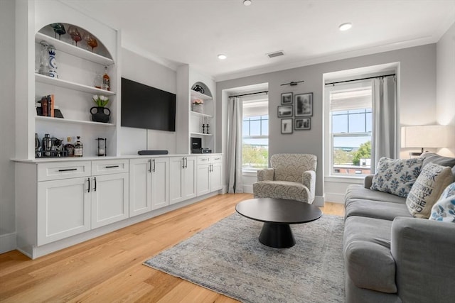 living area with recessed lighting, light wood-style flooring, built in features, and visible vents