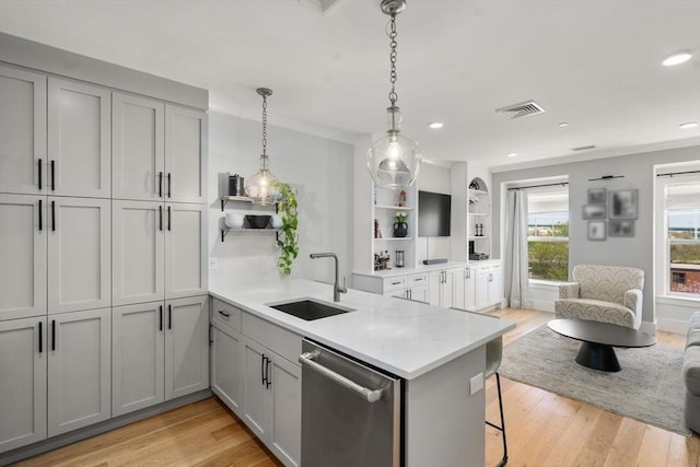 kitchen featuring open shelves, a sink, light wood-style floors, dishwasher, and a peninsula