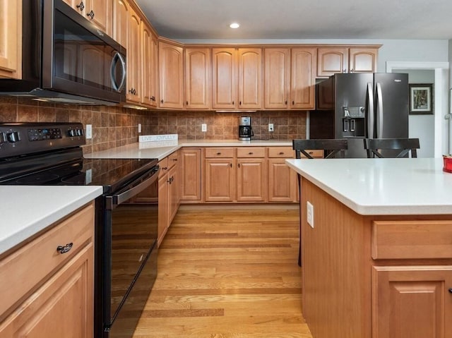 kitchen featuring light countertops, stainless steel refrigerator with ice dispenser, light wood-style flooring, and black electric range oven