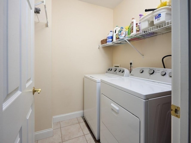 laundry room featuring light tile patterned floors, laundry area, baseboards, and washer and dryer