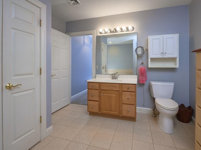 bathroom with baseboards, vanity, toilet, and tile patterned floors